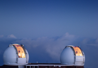 The twin Keck telescopes take their final views of the cosmos as the sun begins to rise over Mauna Kea. - Rick Peterson/WMKO