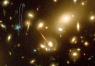 Galaxy cluster Abell 2218 is acting as a powerful lens, magnifying all galaxies lying behind the cluster’s core. The lensed galaxies are all stretched along the shear direction, and some of them are multiply imaged. Those multiple images usually appear as pair of images with a third—generally fainter—counter image, as is the case for the very distant object. - ESA, NASA, J.-P. Kneib (Caltech/Observatoire Midi-Pyrenees) and R. Ellis (Caltech)